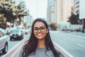 Smiling woman wearing glasses with street behind her