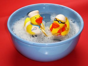 2 rubber ducks in a bath tub.