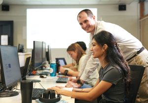 Trainer with student on a desktop computer