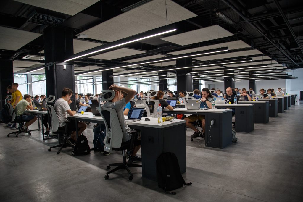 Large group of people working in an open plan office on computers