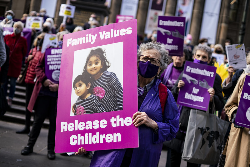 Image of protesters holding a sign saying 'Family Values, Release the Children' with an image of the two Murugappan children at a protest.