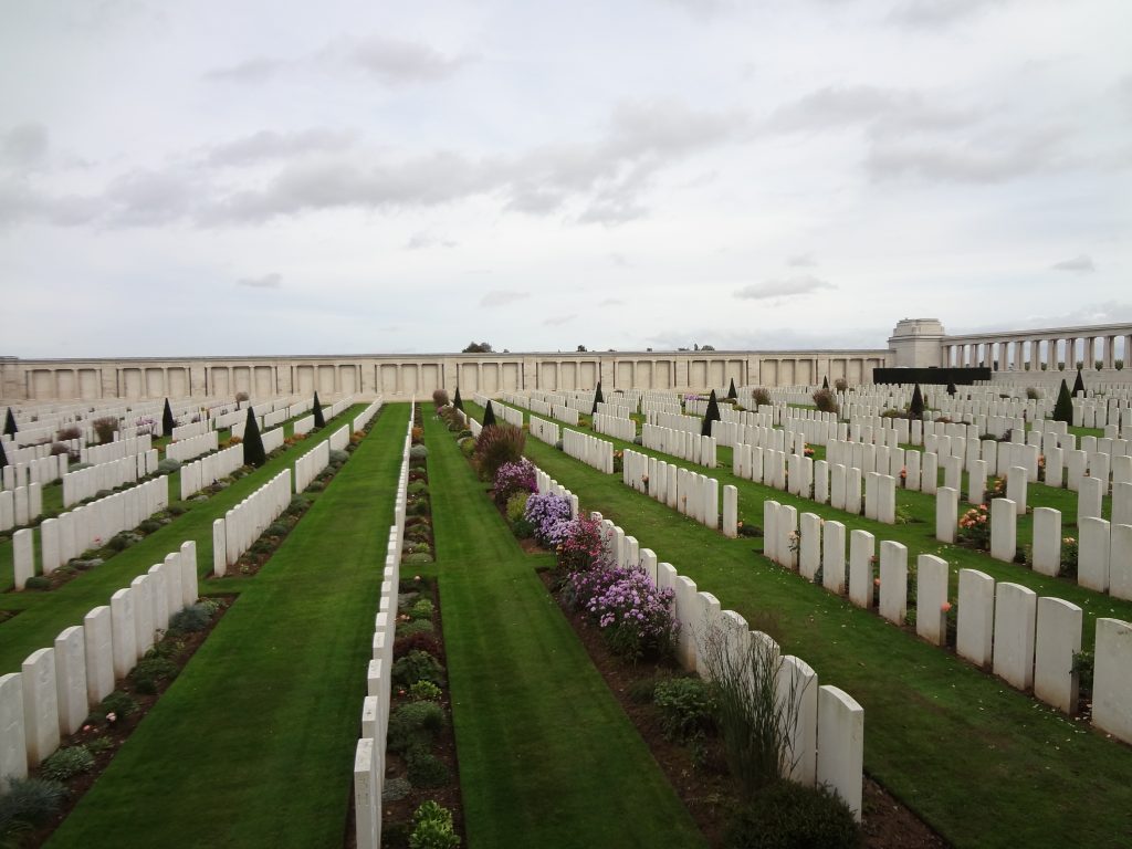 A large walled military cemetery located near Pozières on the Somme, France, showing the white headstones common to Commonwealth War Graves Commission cemeteries.