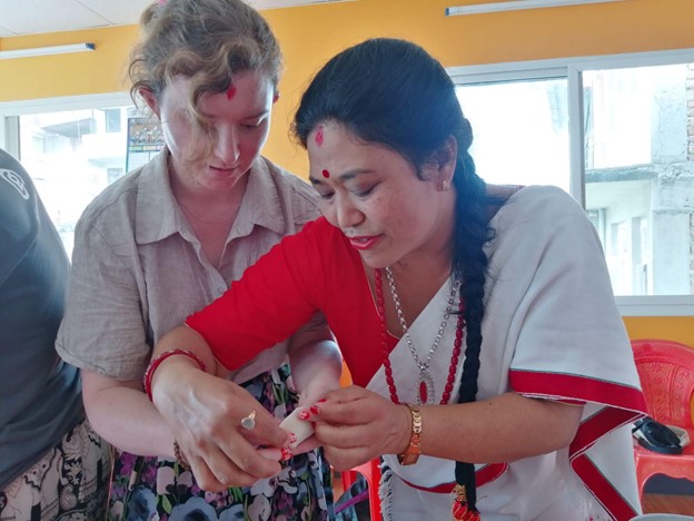 A local host in Kirtipur showing travelers how to fold momo (Nepali Dumplings) during a cooking session at the community homestay.