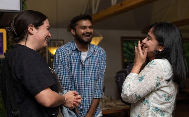 CHN team members Aayusha Prasain (right) and Saurav Lamichhane (center) welcome FAM trip participant Stephenie Hays (left) during a conversation at the Community Connect 2025 orientation dinner.