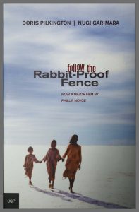 Book cover shows 3 Aboriginal girls holding hands walking in the desert