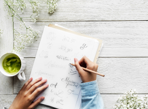 Person writing different types of text on a piece of paper.