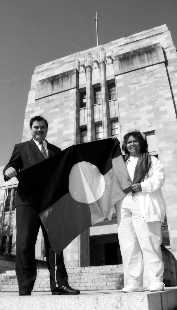 Lilla Watson and Matt Foley raising the flag.